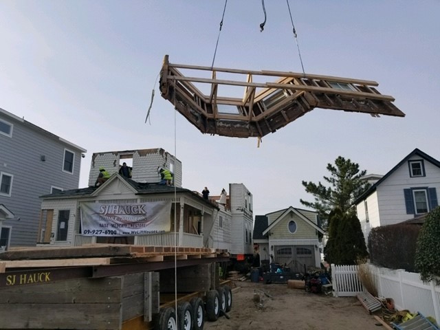 The house being delivered in sections off a flatbed truck